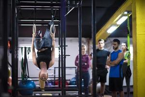 woman working out with personal trainer on gymnastic rings photo