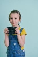 Cute little girl taking picture using  film photo camera