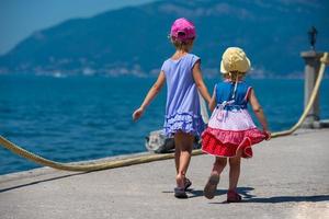 little sisters walking on the beach coast photo