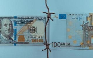conflictos euro-dólar, billete dólar y billete euro, euro vs dólar con alambre de púas, crisis económica foto