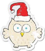 retro distressed sticker of a cartoon owl wearing christmas hat vector