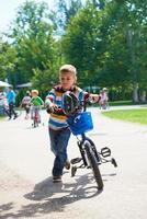 niño feliz aprendiendo a andar en bicicleta foto