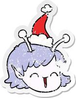 distressed sticker cartoon of a alien space girl face wearing santa hat vector
