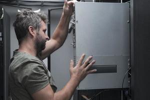el ingeniero que trabaja en la sala de servidores o en el centro de datos, el técnico coloca en un rack un nuevo servidor de supercomputadora de mainframe de negocios corporativos o granja de minería de criptomonedas. foto
