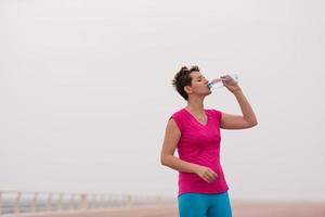 Fitness woman drinking water photo