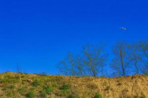 Excavated sand mountains and rubble piles quarry lake dredging pond. photo