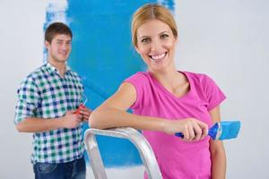 happy couple paint wall at new home photo