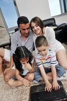 happy young family have fun and working on laptop at home photo