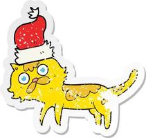 retro distressed sticker of a cartoon cat wearing christmas hat vector