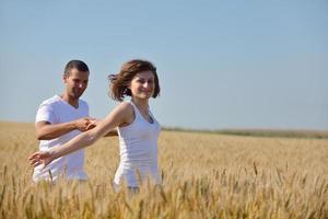 pareja feliz en campo de trigo foto