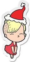 sticker cartoon of a squinting girl in dress wearing santa hat vector