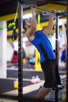 man doing pull ups on the horizontal bar photo