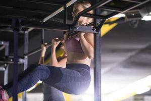 young athletes doing pull ups on the horizontal bar photo