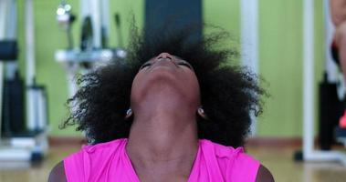 mujer de espalda en un gimnasio estirando y calentando foto