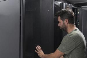 Technicians team updating hardware inspecting system performance in super computer server room or cryptocurrency mining farm. photo