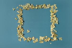 Golden frame and dried hydrangea flowers on a green background. Vertical format. Flat lay, top view, copy space photo