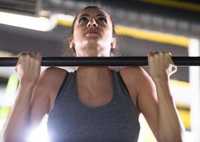 woman doing pull ups on the horizontal bar photo