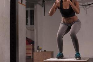 mujer negra está realizando saltos de caja en el gimnasio foto