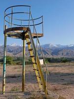 Structure on an abandoned playground in Kyrgyzstan with mountains in the background photo