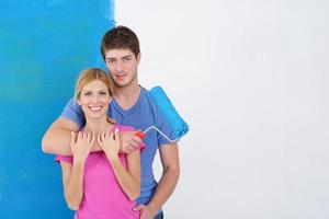 happy couple paint wall at new home photo