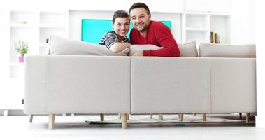 Young couple on the sofa watching television photo