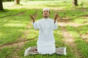 A middle-aged Asian Muslim man prays at his home during the month of Ramadan photo