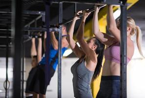 young athletes doing pull ups on the horizontal bar photo