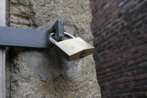 Metal padlock at an old wooden gate photo