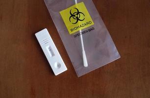 Coronavirus - COVID-19 - rapid test with negative result next to a nasal swab in a transparent bag with bio hazard photo