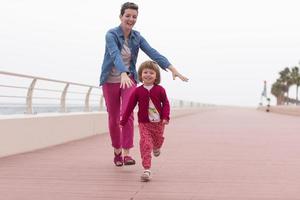 mother and cute little girl on the promenade by the sea photo