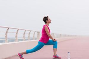 mujer estirándose y calentándose en el paseo marítimo foto