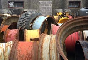 Pile of old tires and metal rims in a backyard photo