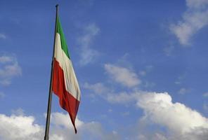 bandera nacional italiana desinflada contra un cielo azul foto