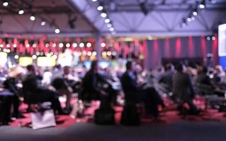 Anonymized photo with blurred out audience at a conference listening to a presentation