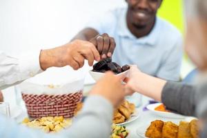 modern multiethnic muslim family sharing a bowl of dates photo