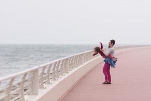 madre y niña linda en el paseo marítimo junto al mar foto