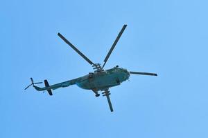 Navy helicopter flying against blue sky, copy space. One military warfare helicopter, bottom view photo