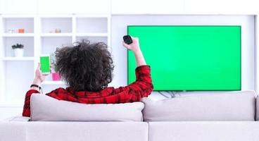 Young couple on the sofa watching television photo