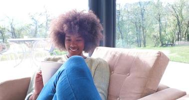 african american woman at home using digital tablet photo