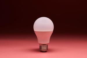 Light bulb, copy space. Energy saving minimal idea concept.Pink background. photo