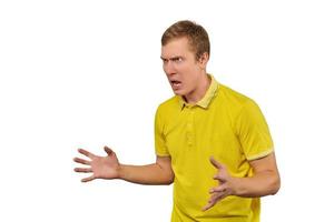 Aggressive angry man in yellow T-shirt ready to fight with fists isolated on white background photo