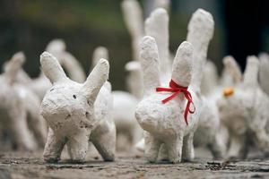 White rabbit statues made of plaster at outdoor art exhibition, funny white hares on street photo