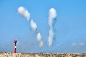 White carbon fiber clouds in blue sky hiding naval destroyers from anti-ship missiles, military show photo