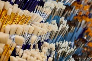 New artistic paint brushes on shelf in stationery shop photo