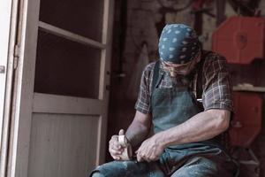 Spoon craft master in his workshop with handmade wooden products and tools working photo