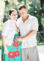 Happy pregnant couple at beautiful sunny day in park photo