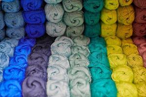 Yarns or balls of wool on shelves in store for knitting photo