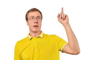 Funny young guy in corrective glasses and yellow T-shirt with eureka gesture, man got idea isolated photo