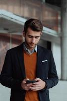 businessman architect using a smartphone while overseeing the construction site photo