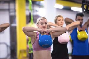 athletes doing exercises with kettlebells photo